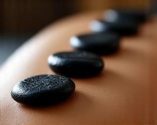 Smooth black stones on a person's back